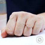 Close-up of marquise moissanite curved band showing delicate sparkle on hand