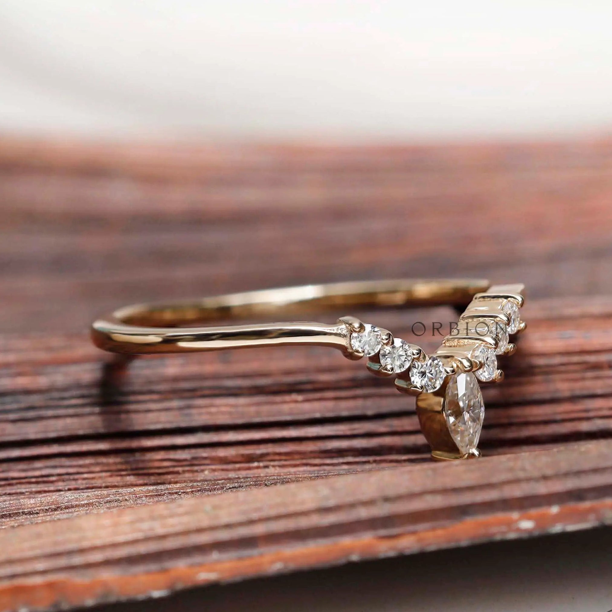 Angled view of chevron contour moissanite band showing marquise center stone detail