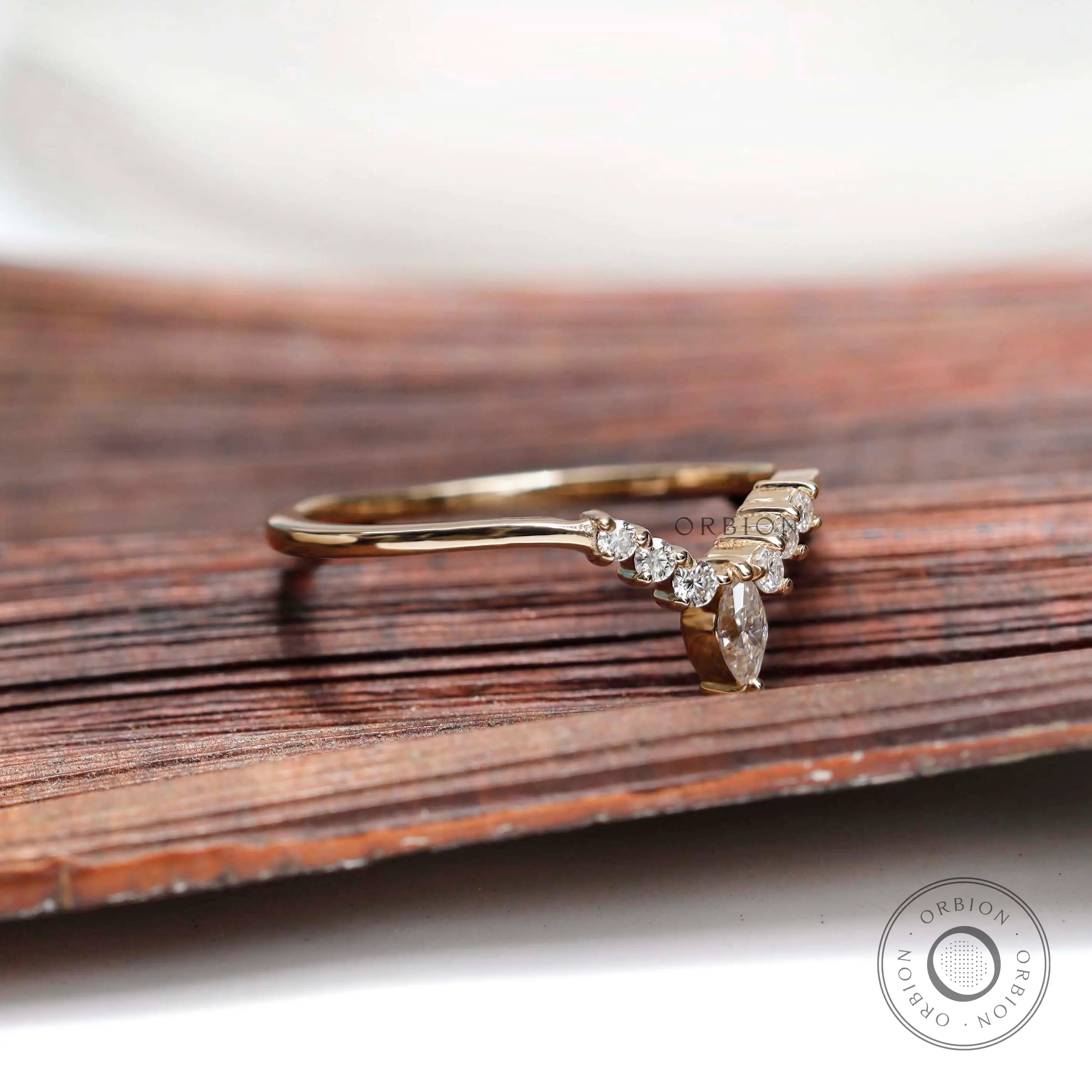 Angled view of chevron contour moissanite band showing marquise center stone detail