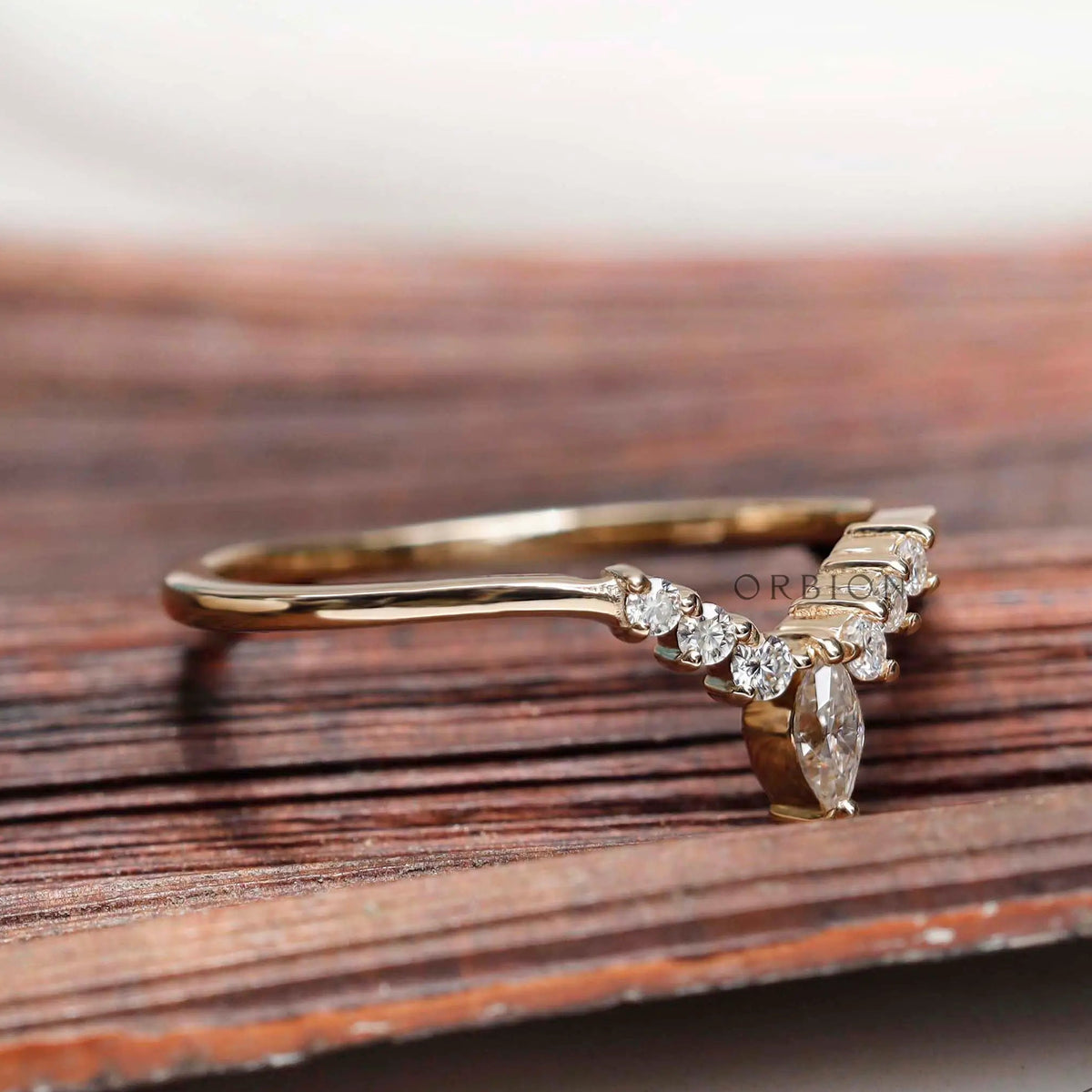 Angled view of chevron contour moissanite band showing marquise center stone detail