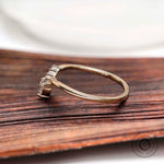 Side profile of marquise and round moissanite V shaped wedding band in solid gold
