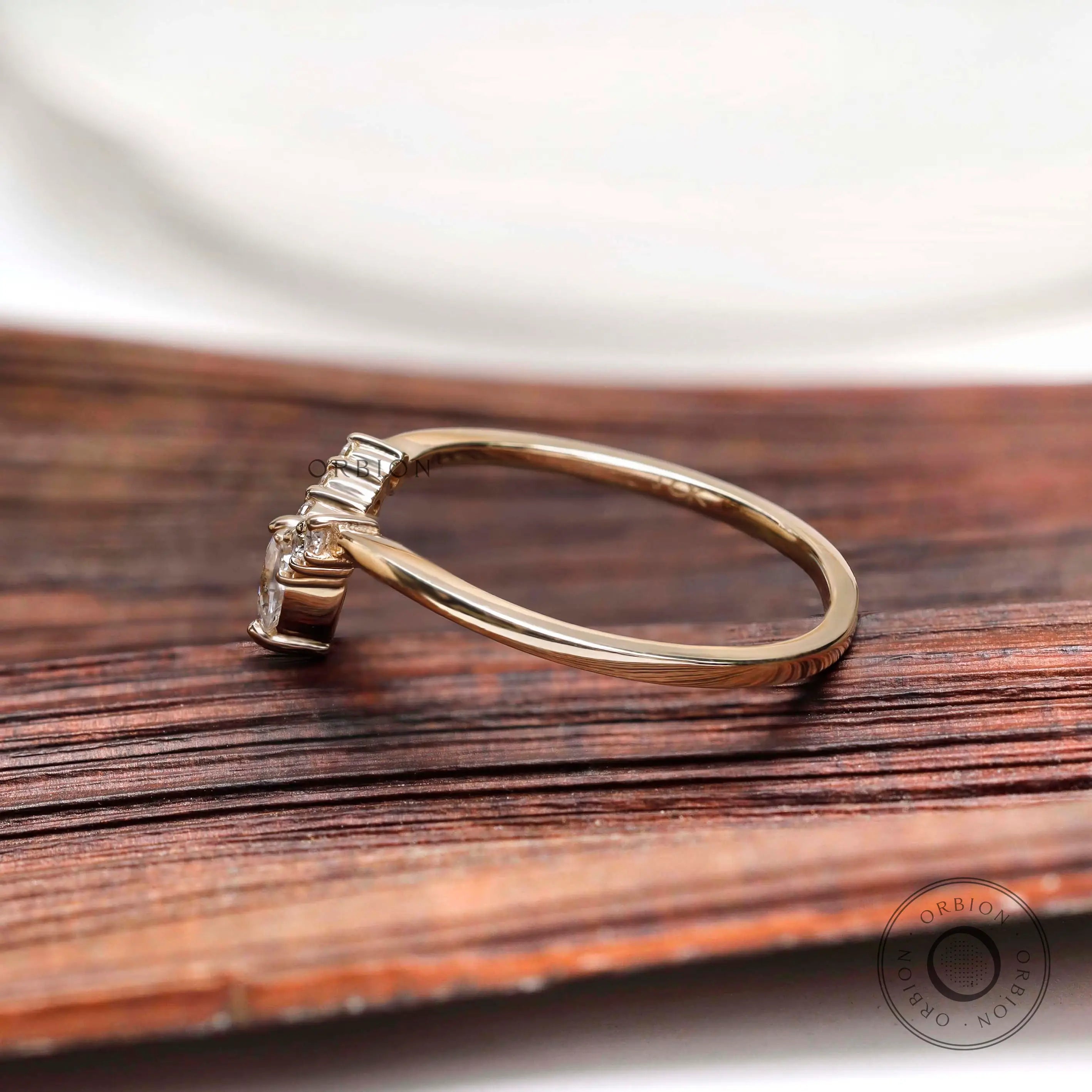 Side profile of marquise and round moissanite V shaped wedding band in solid gold