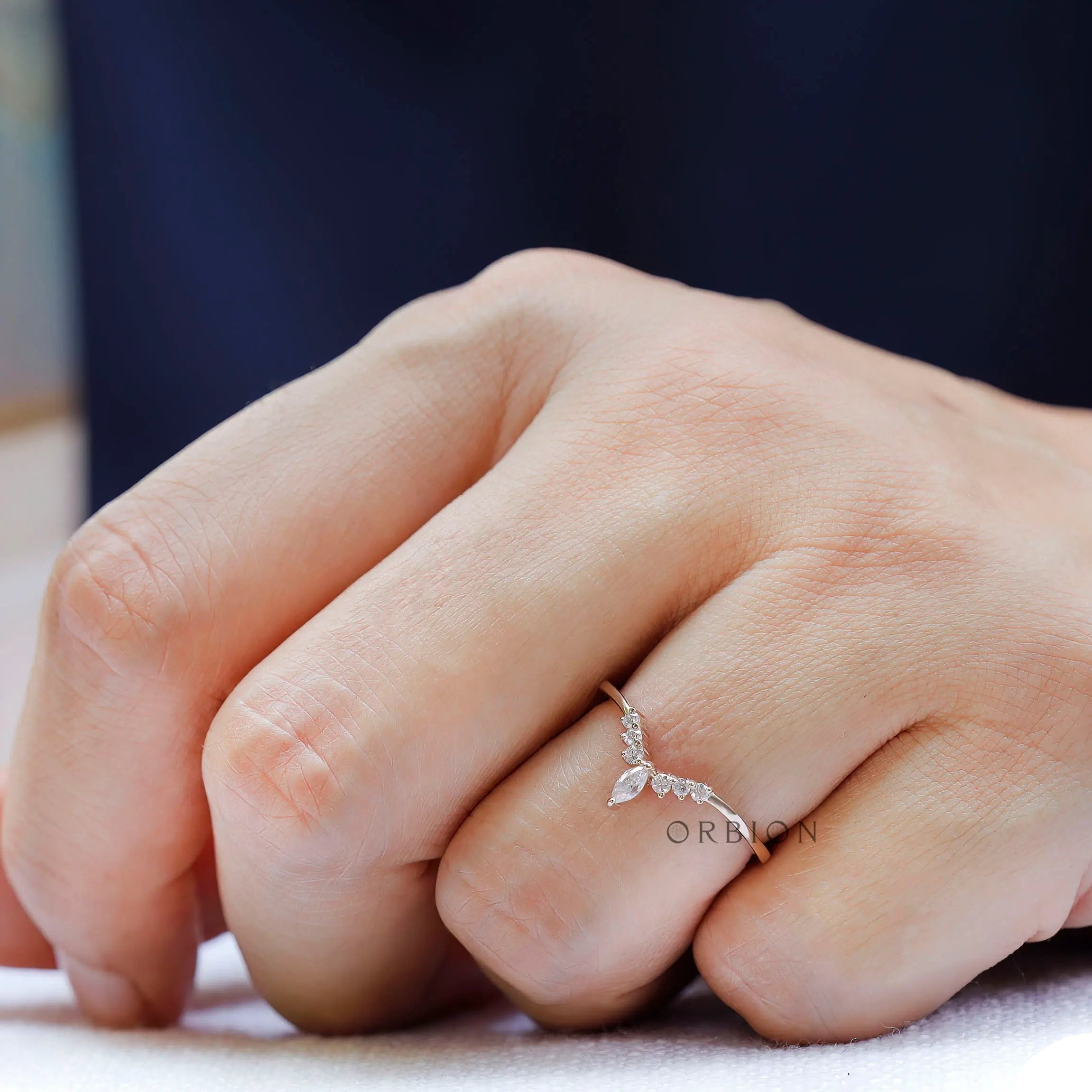 Marquise and round cut moissanite wedding band worn on finger lifestyle view