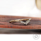 Angled view of thin V shaped moissanite band