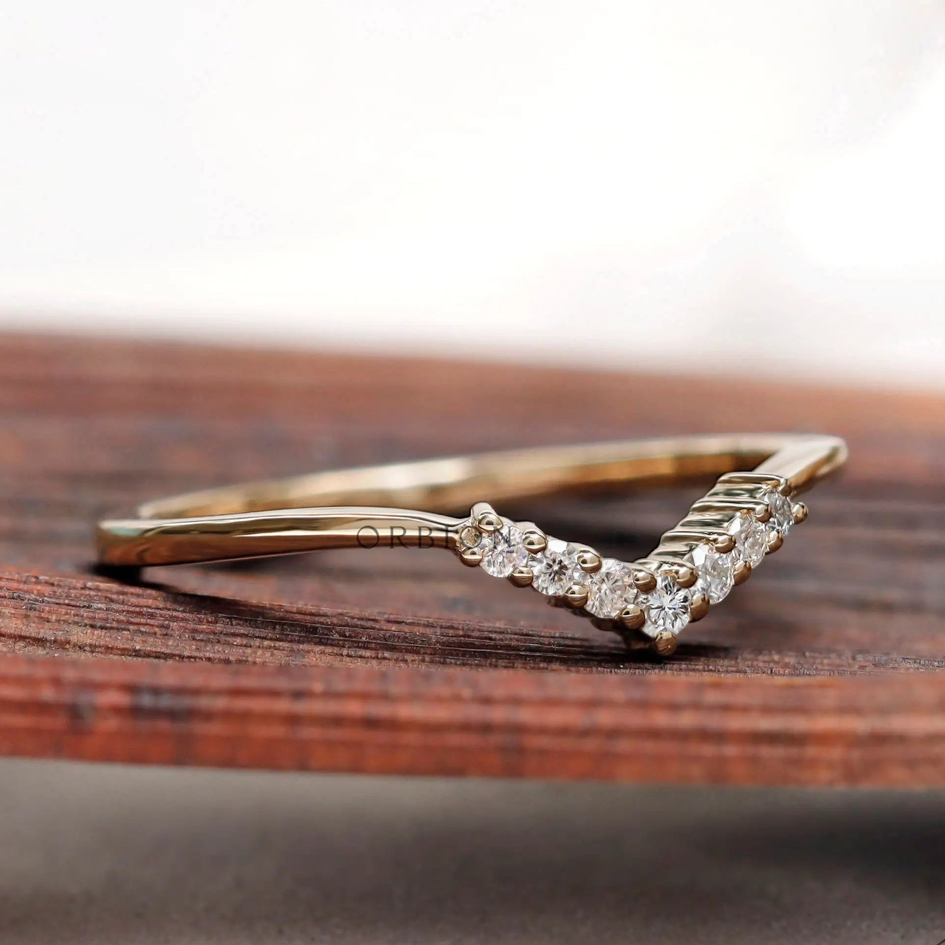 Angled view of thin V shaped moissanite band