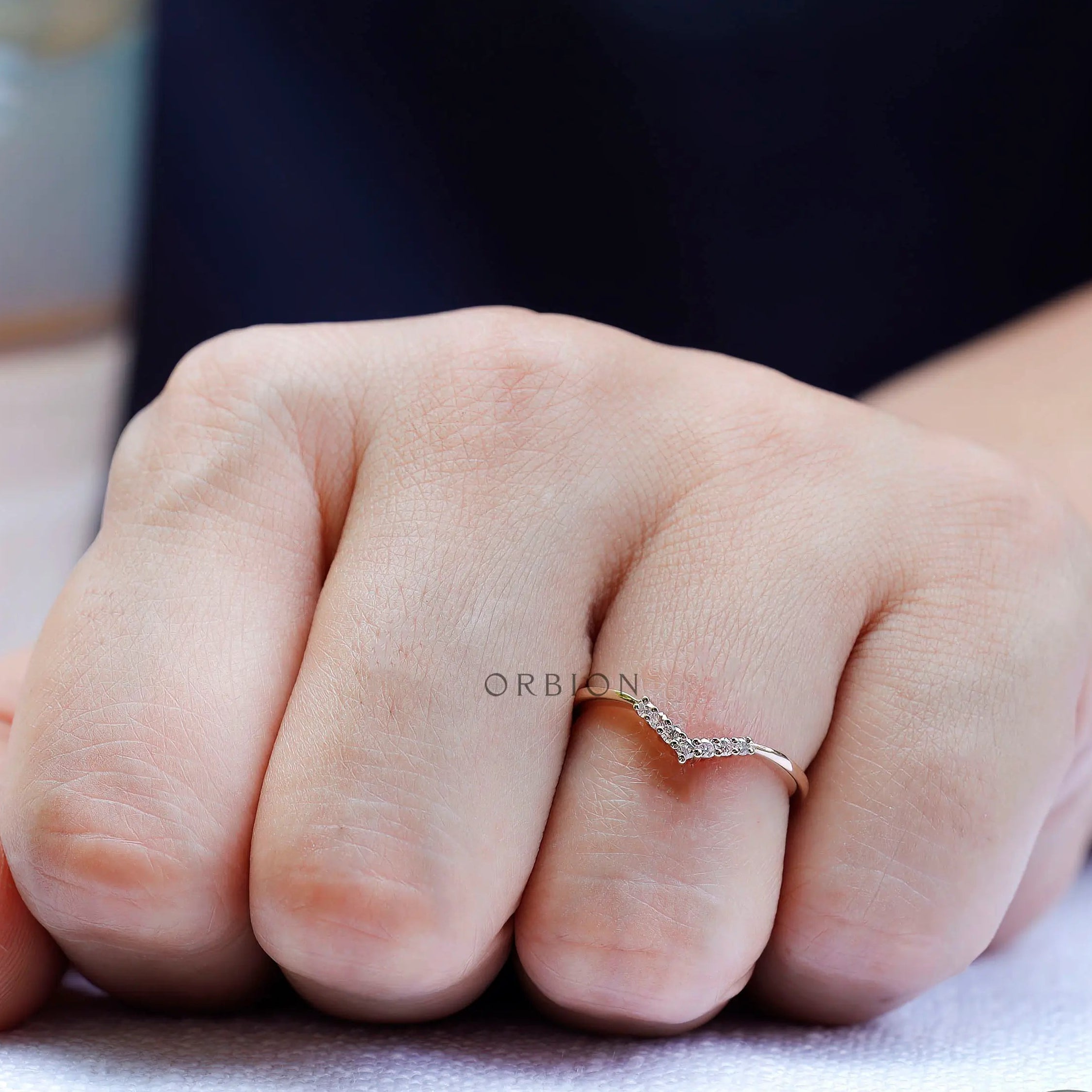 Minimal V shaped moissanite band worn on hand