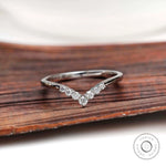 Front view of chevron moissanite wedding band on wooden surface