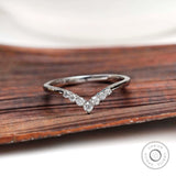 Front view of chevron moissanite wedding band on wooden surface