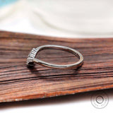 Side profile of V shaped moissanite wedding band showing stone setting