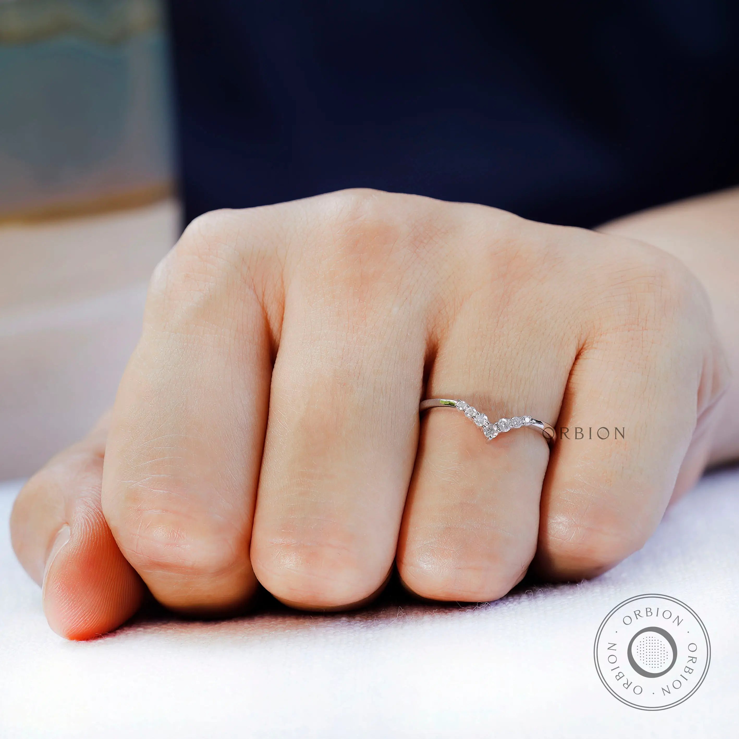 Close up of V shaped moissanite stones showing sparkle detail worn on hand