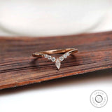 Front view of chevron moissanite wedding band on wooden surface