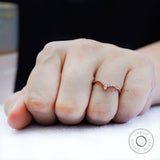 On-hand view of chevron moissanite wedding band worn on finger