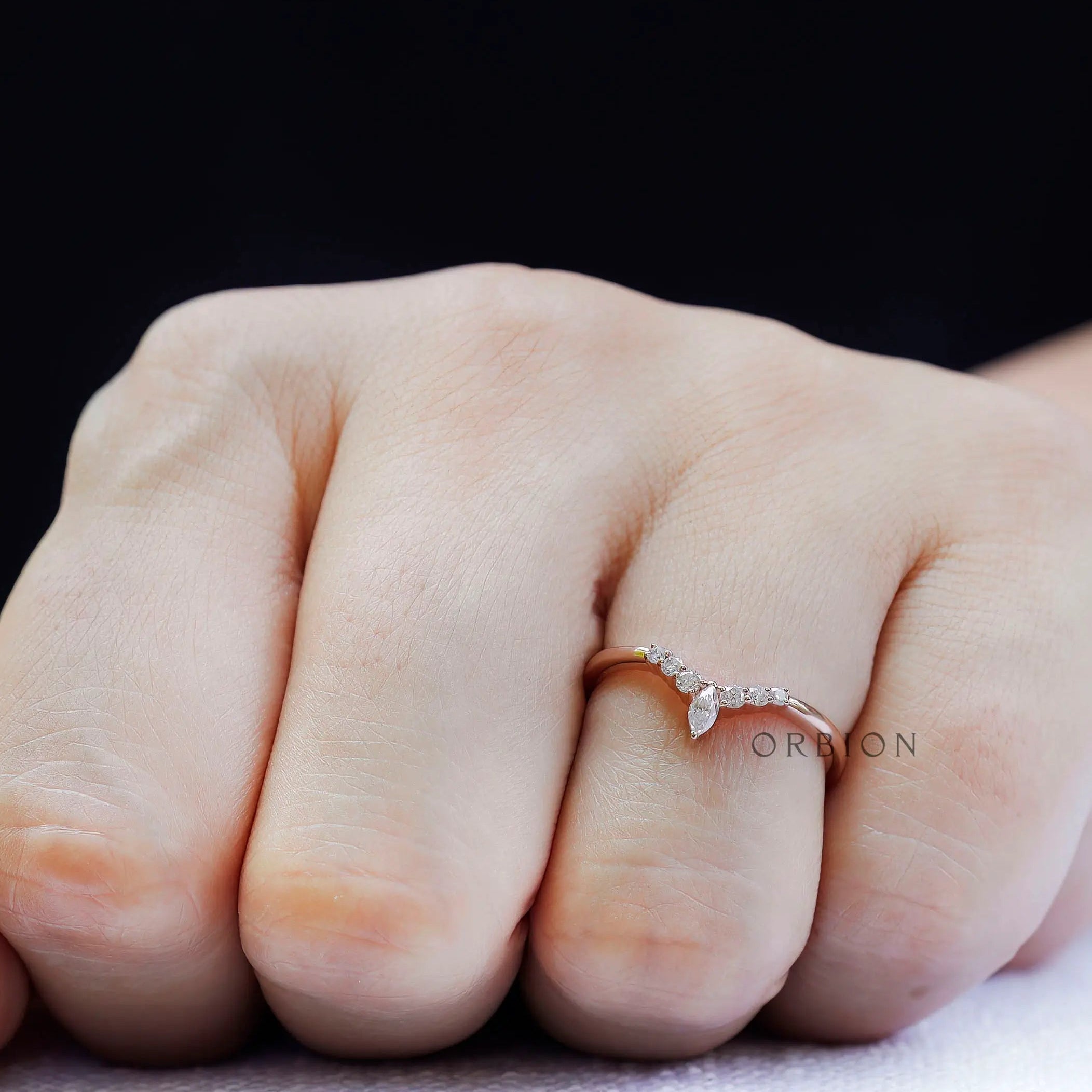 On-hand view of chevron moissanite wedding band worn on finger