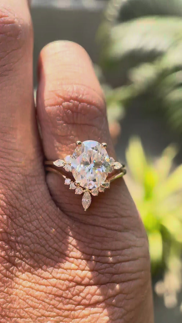 Oval moissanite cluster bridal ring set in 14K yellow gold.