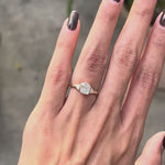 Cushion cut bezel set center stone engagement ring with prong set trillion accents