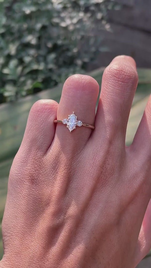 Delicate marquise center stone engagement ring with round side stones yellow gold video