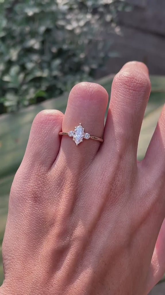 Delicate marquise center stone engagement ring with round side stones yellow gold video