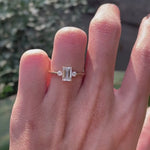 Delicate emerald cut engagement ring with round side stones on hand video