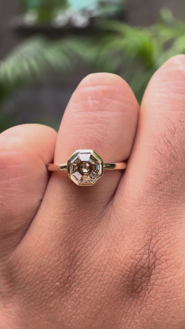 Dark champagne moissanite octagon ring on hand in 10k yellow gold bezel setting video