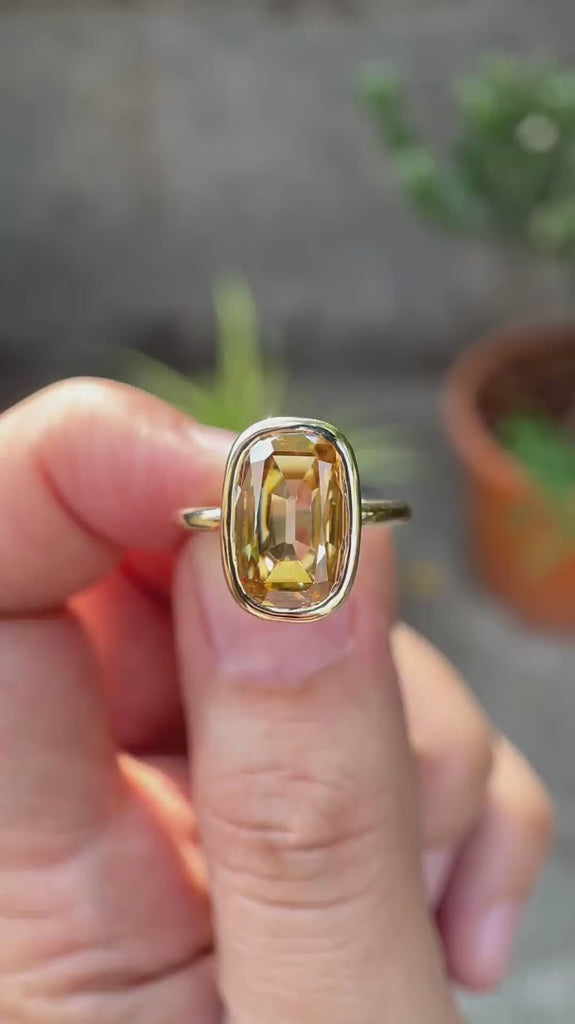Video showcasing the elongated champagne moissanite bezel ring in  yellow gold.