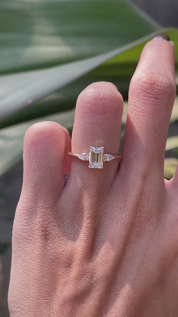 Emerald cut center with pear side stones engagement ring yellow gold video