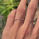 Close rotating view of slim pave moissanite wedding band in rose gold.