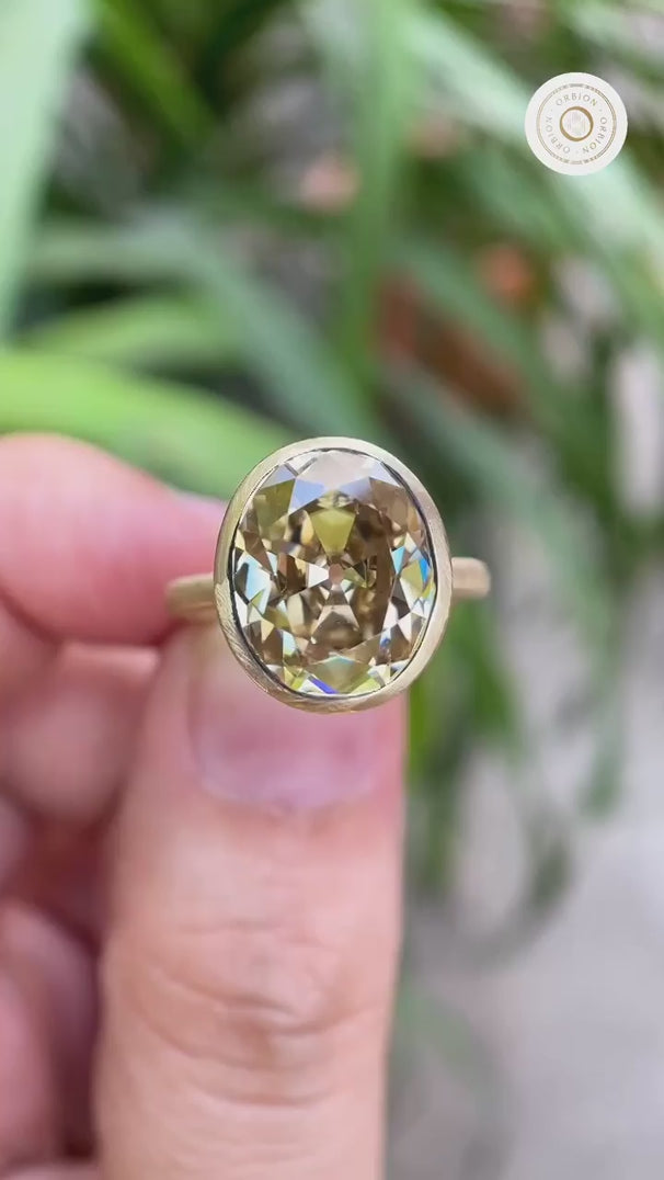 Bezel set oval champagne ring rotating in hand