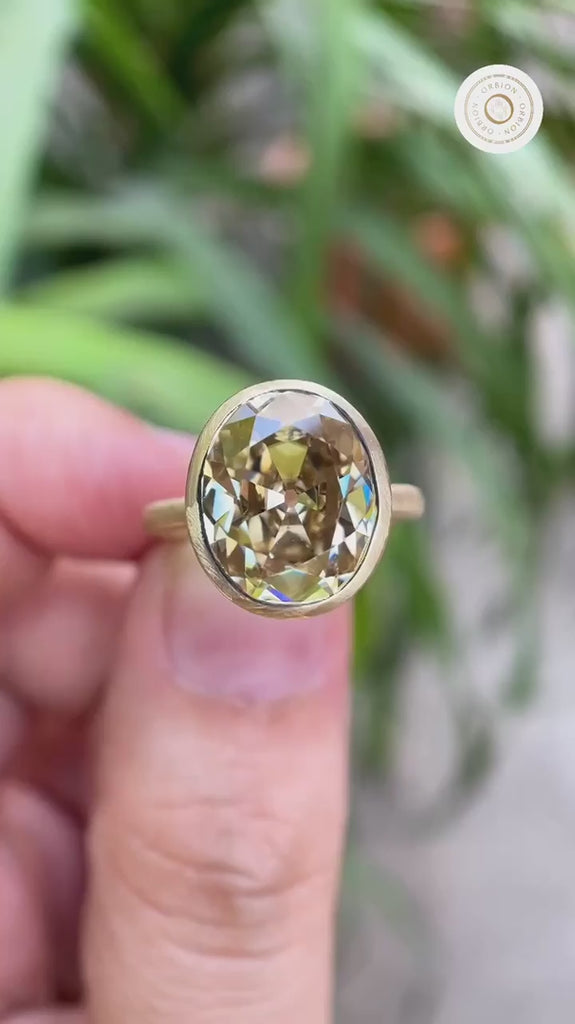 Bezel set oval champagne ring rotating in hand