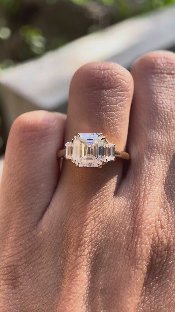 Rotating video of Asscher three stone ring showcasing step cut sparkle and double claw prongs