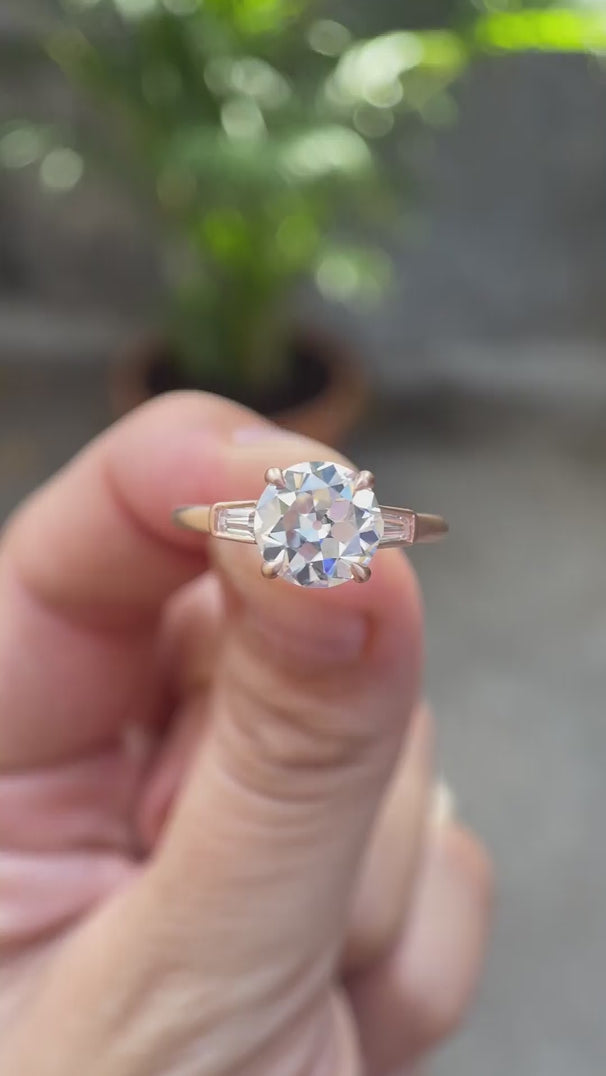 Round Old European Cut Moissanite Cathedral Three Stone Ring with Baguette Accents in 10K rose gold rotating view