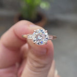 Round Old European Cut Moissanite Cathedral Three Stone Ring with Baguette Accents in 10K rose gold rotating view