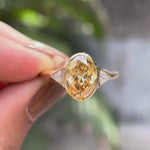 Elongated oval bezel set three stone ring in yellow gold rotating view