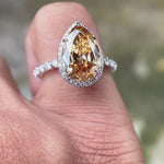 Video showcasing the pear-shaped Moissanite Old Mine Cut halo ring with round side stones in 14K white gold.
