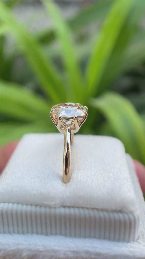 Light champagne cushion Old Mine Cut moissanite solitaire ring in 10K yellow gold rotating view