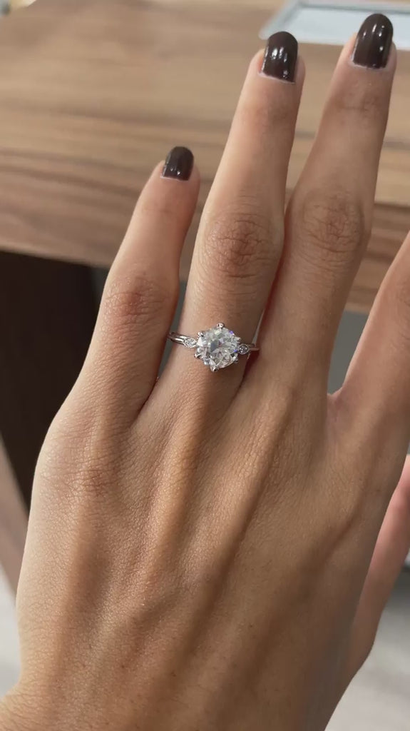 Rotating view of three stone Old European cut ring on hand