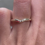 Close rotating view of curved starburst diamond ring on finger.
