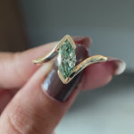 Rotating view light blue green marquise lab diamond half bezel ring.