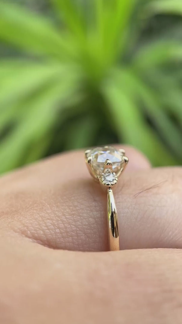 Video showing the 10K yellow gold engagement ring with a square cushion moissanite center stone and round brilliant-cut side stones, highlighting its high-polish finish and elegant design.