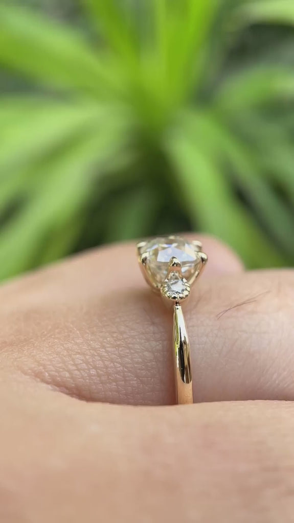 Video showing the 10K yellow gold engagement ring with a square cushion moissanite center stone and round brilliant-cut side stones, highlighting its high-polish finish and elegant design.