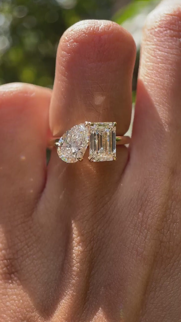 Close-up video of pear and emerald cut toi et moi ring in yellow gold