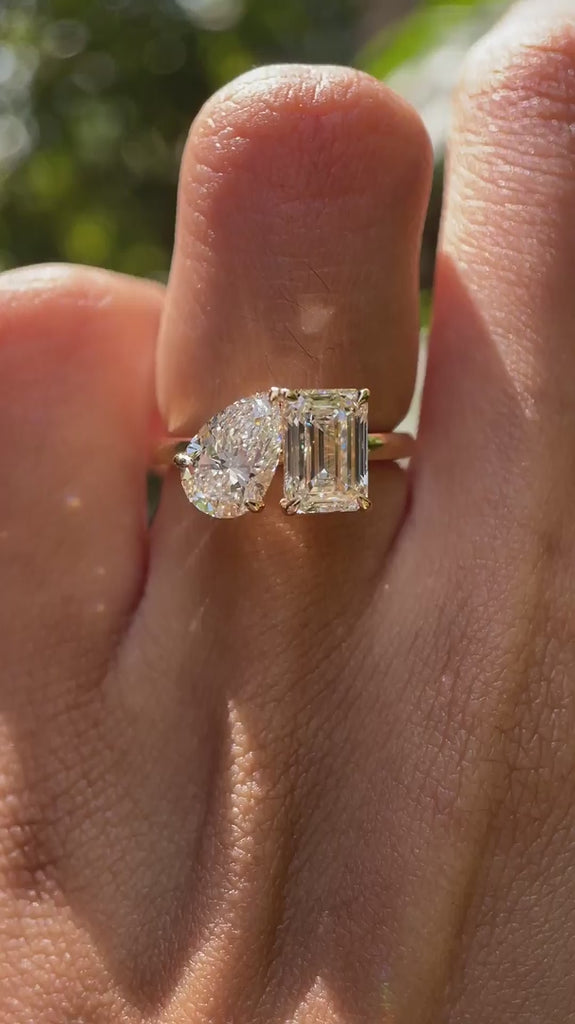 Close-up video of pear and emerald cut toi et moi ring in yellow gold