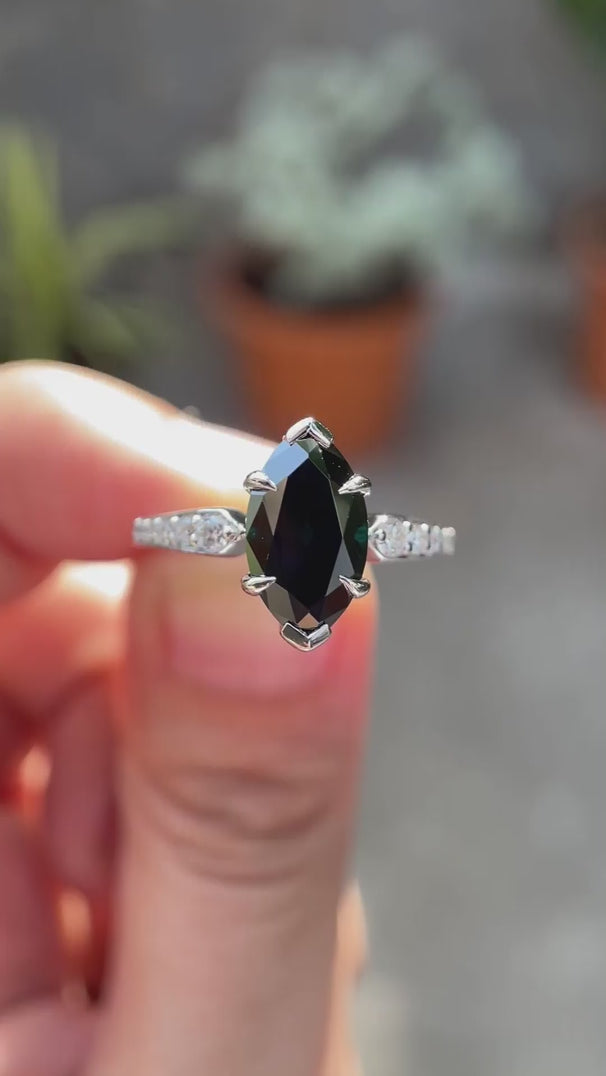 Deep green Old Mine Cut marquise moissanite engagement ring in 10K white gold shown in motion highlighting brilliance and tapered band detailing