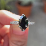 Deep green Old Mine Cut marquise moissanite engagement ring in 10K white gold shown in motion highlighting brilliance and tapered band detailing