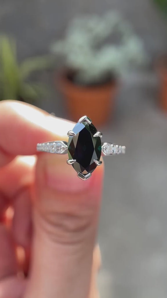 Deep green Old Mine Cut marquise moissanite engagement ring in 10K white gold shown in motion highlighting brilliance and tapered band detailing