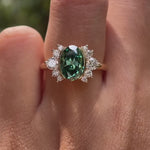 360-degree rotating view of green oval moissanite floral cluster ring in yellow gold