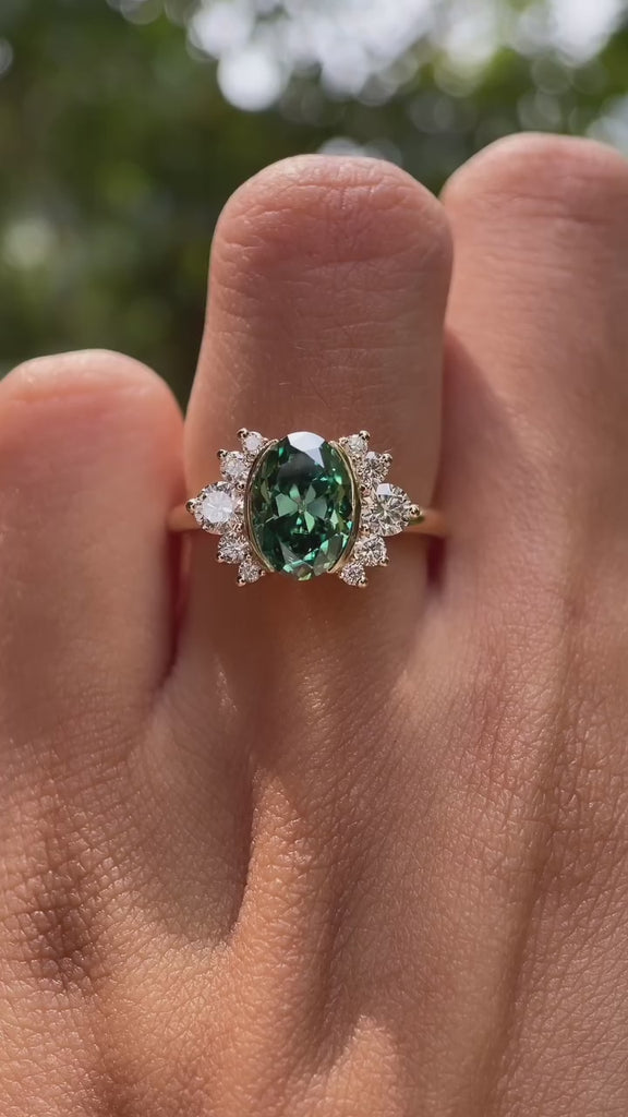 360-degree rotating view of green oval moissanite floral cluster ring in yellow gold