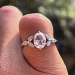 Video displaying oval rose cut moissanite with marquise diamond cluster design