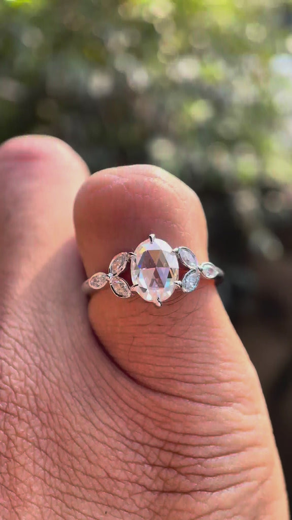 Video displaying oval rose cut moissanite with marquise diamond cluster design