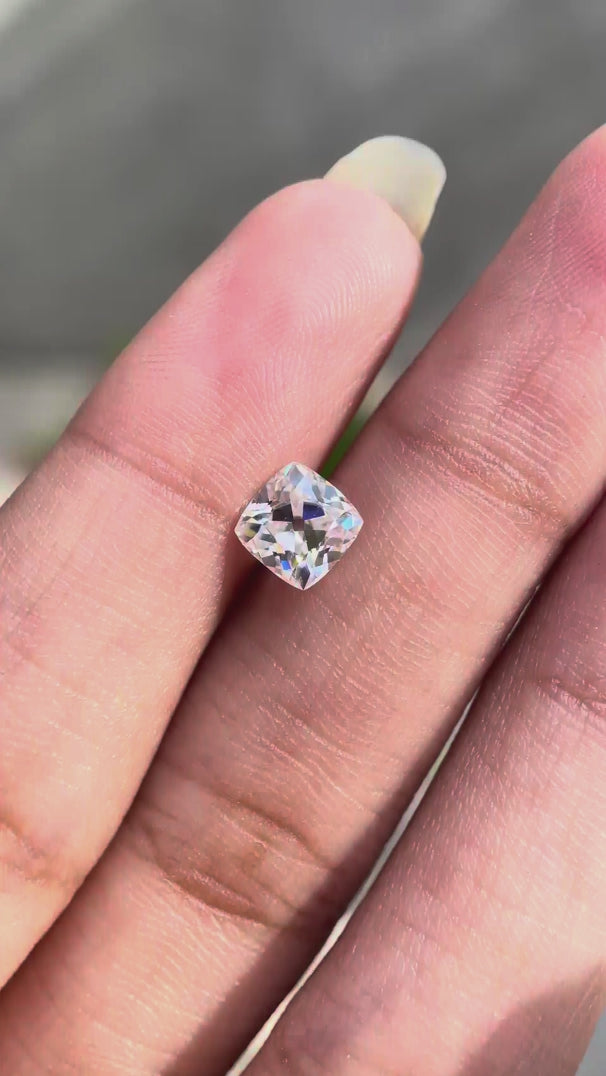 Cushion Peruzzi cut moissanite rotating to show brilliance and faceting