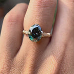 Rotating view of blue green oval moissanite cathedral ring worn on hand
